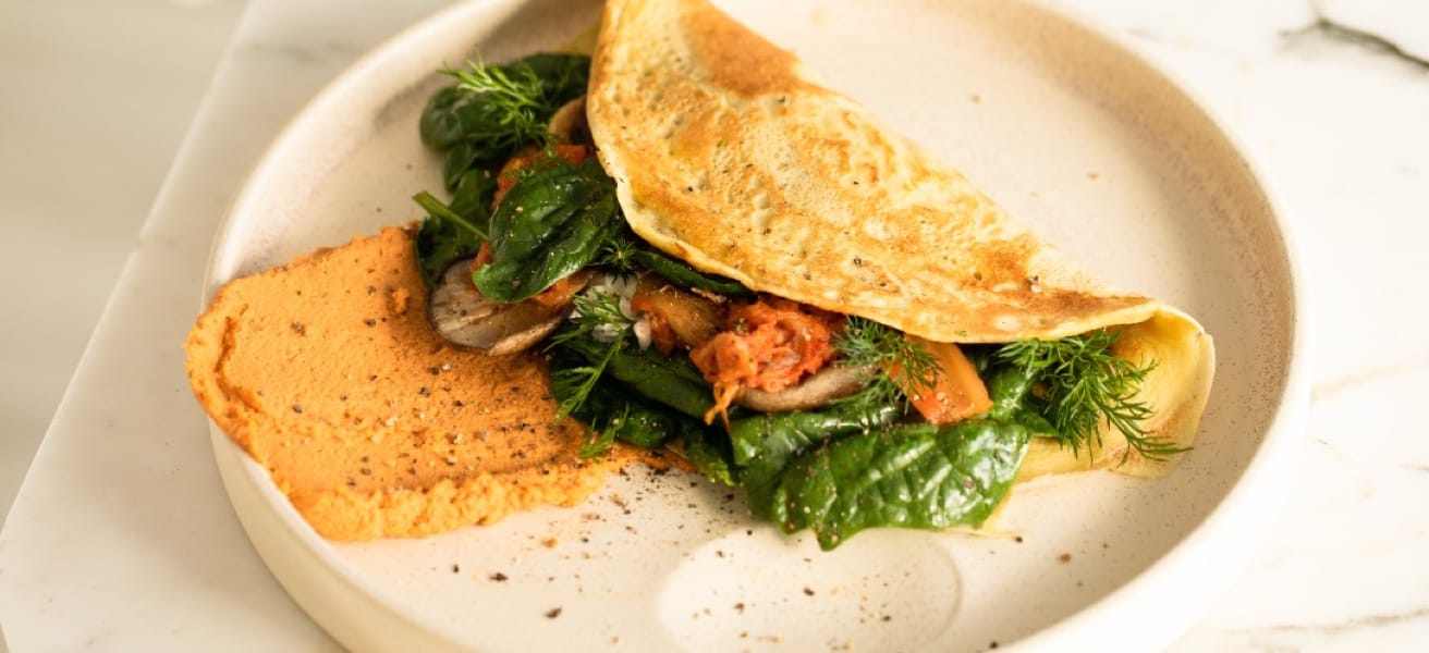 omelette filled with vegetables and herbs on a plate